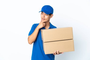 Teslimatçı Çinli adam beyaz arka planda izole edilmiş, yana bakıyor ve gülümsüyor.