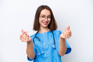 Young nurse Ukrainian woman isolated on white background making money gesture