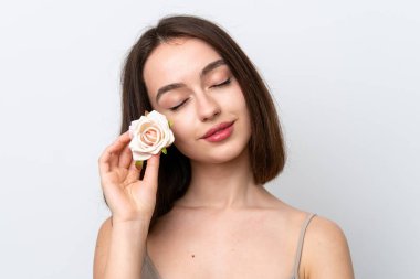 Genç Ukraynalı bir kadın elinde çiçeklerle beyaz arka planda izole edilmiş. Portreyi kapat