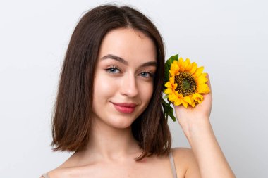 Genç Ukraynalı kadın gülümserken elinde ayçiçeği tutarak beyaz arka planda izole edilmiş. Portreyi kapat