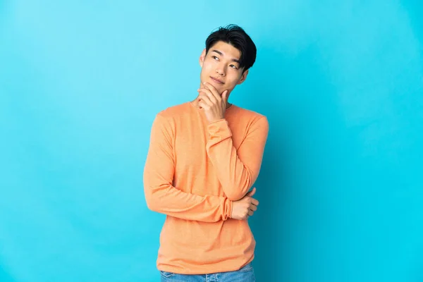 Young Chinese Man Isolated Blue Background Looking — Stok fotoğraf