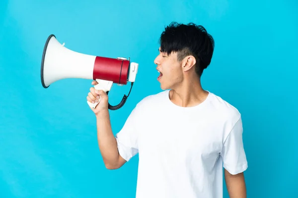 Jonge Chinese Man Geïsoleerd Blauwe Achtergrond Schreeuwen Door Een Megafoon — Stockfoto