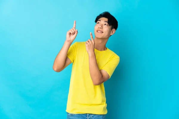Young Chinese Man Isolated Blue Background Pointing Index Finger Great — Φωτογραφία Αρχείου