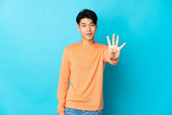 Ung Kinesisk Man Isolerad Blå Bakgrund Glad Och Räkna Fyra — Stockfoto