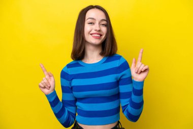 Sarı arka planda izole edilmiş genç Ukraynalı kadın harika bir fikre işaret ediyor.