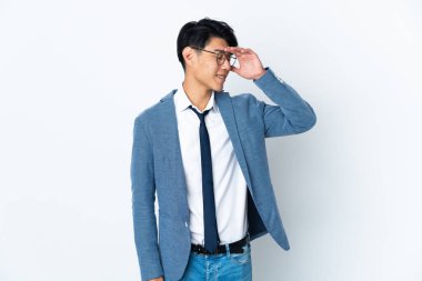 Genç Çinli iş adamı beyaz arka planda izole edilmiş, çok gülümsüyor.