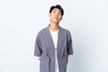 Genç Çinli adam beyaz arka planda izole edilmiş ve araştırıyor.