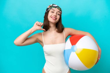 Plaj topu tutan genç Ukraynalı kadın mavi arka planda izole edilmiş gururlu ve kendinden memnun.