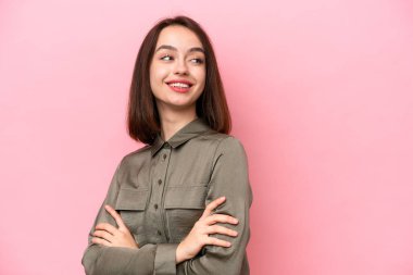 Pembe arka planda izole edilmiş, kolları bağlı ve mutlu genç Ukraynalı bir kadın.