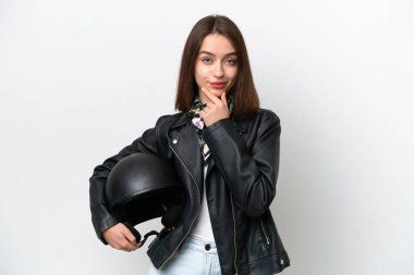 Young Ukrainian woman with a motorcycle helmet isolated on white background thinking