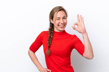 Beyaz arka planda izole edilmiş genç beyaz kadın parmaklarıyla tamam işareti gösteriyor.