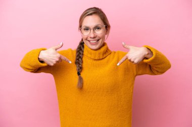 Pembe arka planda yalıtılmış beyaz bir kadın. Şaşırtıcı bir yüz ifadesi var.