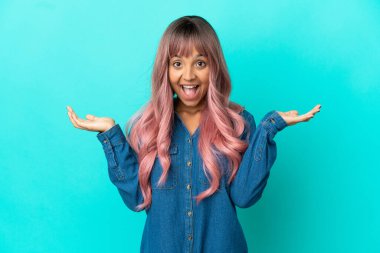 Mavi arka planda pembe saçlı melez bir kadın ve şok olmuş bir yüz ifadesi var.