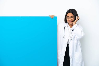 Beyaz arka planda izole edilmiş büyük bir afişi olan genç ırk doktoru hayal kırıklığına uğramış ve kulaklarını kapatmış.