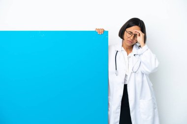 Beyaz arka planda, yorgun ve hasta bir ifadeyle izole edilmiş büyük bir afişi olan genç ırk doktoru kadın.