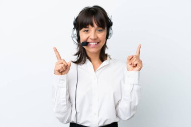 Beyaz arka planda izole edilmiş bir kulaklıkla çalışan pazarlamacı melez kadın harika bir fikre işaret ediyor.