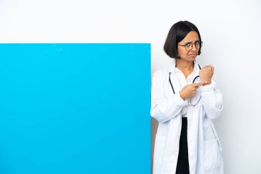Beyaz arka planda izole edilmiş büyük bir pankartla genç melez bir doktor geç kalma jesti yapıyor.