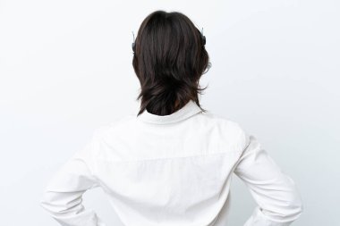 Telemarketer mixed race woman working with a headset isolated on white background in back position