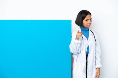 Beyaz arka planda izole edilmiş büyük bir afişi olan genç, melez ırk doktoru kadın hayal kırıklığına uğramış ve ön tarafı işaret ediyor.