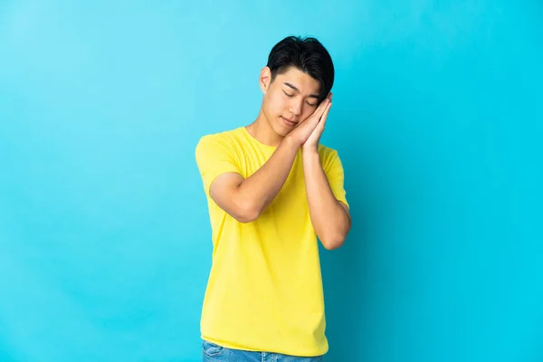 Young Chinese Man Isolated Blue Background Making Sleep Gesture Dorable — Φωτογραφία Αρχείου