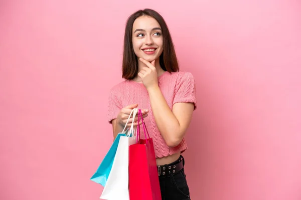 Young Ukrainian Woman Isolated Pink Background Holding Shopping Bags Thinking — Stock Fotó