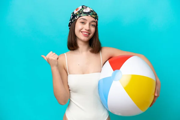 Young Ukrainian Woman Holding Beach Ball Isolated Blue Background Pointing — Stok fotoğraf