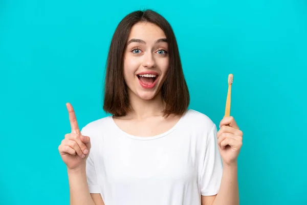 Young Ukrainian Woman Brushing Teeth Isolated Blue Background Pointing Great — стокове фото