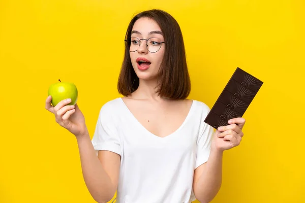 Young Ukrainian Woman Isolated Yellow Background Taking Chocolate Tablet One — Fotografia de Stock