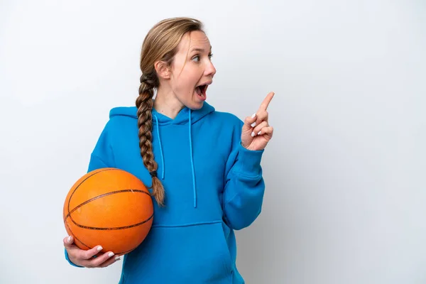 若いです白人女性は指を持ち上げながら解決策を実現しようと白い背景に隔離されたバスケットボールを再生します — ストック写真