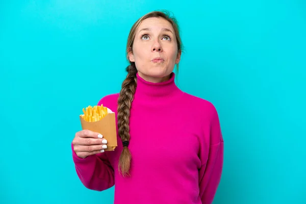 Joven Mujer Caucásica Sosteniendo Chips Fritos Aislados Sobre Fondo Azul —  Fotos de Stock