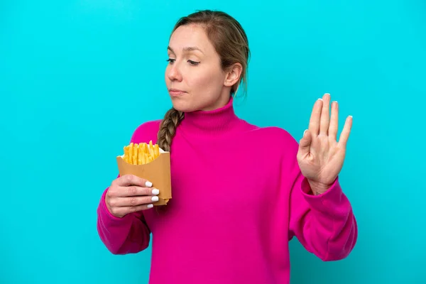Young Caucasian Woman Holding Fried Chips Isolated Blue Background Making — ストック写真