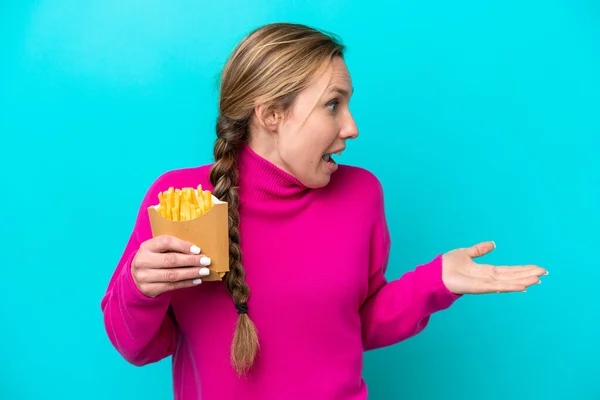Young Caucasian Woman Holding Fried Chips Isolated Blue Background Surprise — Stockfoto