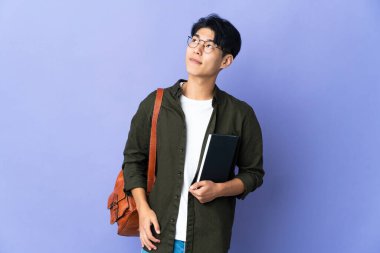 Mor arka planda izole edilmiş genç bir bayan bir fikir ararken,