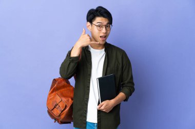 Mor arka planda izole edilmiş genç bir bayan telefon jesti yapıyor. Bana geri dönüş işareti ver.