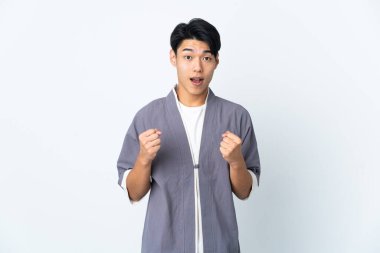 Genç Çinli adam beyaz arka planda tek başına zaferi kutluyor.