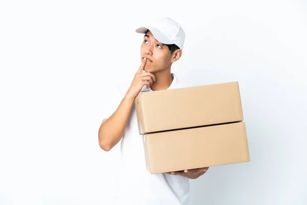 Delivery Chinese Man Isolated White Background Having Doubts While Looking — Stockfoto