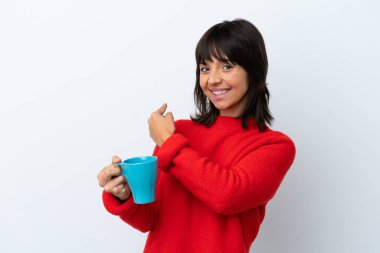 Young caucasian woman holding cup of coffee isolated on white background pointing back