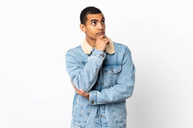 İzole edilmiş beyaz arka planı olan Afrikalı Amerikalı bir adam yukarı bakarken bir fikir düşünüyor.