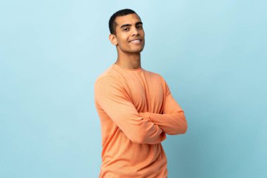 Afrika kökenli Amerikalı bir adam kollarını kavuşturup ileriye bakıyor.