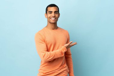 İzole edilmiş arka planda yaşayan Afrikalı Amerikalı bir adam gülümseyerek bir fikir sunuyor.