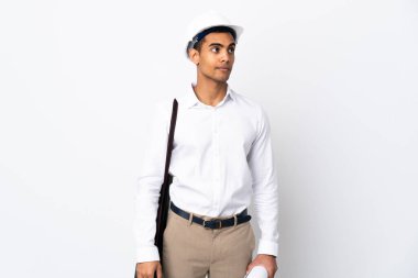 Miğferi olan ve izole edilmiş beyaz arkaplan üzerinde planları olan Afrikalı Amerikalı mimar şüpheli hareketlerde bulunuyor.