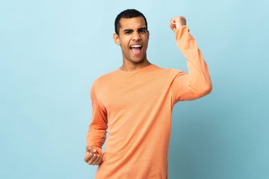 Afrikalı Amerikalı erkek izole edilmiş arka planda zaferi kutluyor.