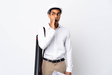 Miğferli Afrikalı Amerikalı mimar, izole edilmiş beyaz arka plan üzerinde planlar tutuyor. Yan tarafa bakarken sürpriz bir jest yaparak bir şeyler fısıldıyor.