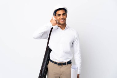 Miğferli Afrikalı Amerikalı mimar izole edilmiş beyaz arka plan üzerinde planlar tutuyor ve telefon jesti yapıyor. Bana geri dönüş işareti ver.