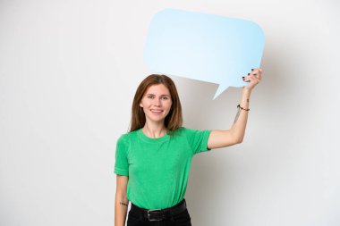 Beyaz arka planda izole edilmiş genç bir İngiliz kadın boş bir konuşma balonu tutuyor.