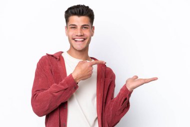 Beyaz arka planda izole edilmiş genç beyaz bir adam bir ilan vermek için avucunun içinde hayali bir fotokopi makinesi tutuyor.