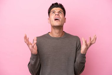 Pembe arka planda izole edilmiş genç beyaz adam bunalıma girdi.