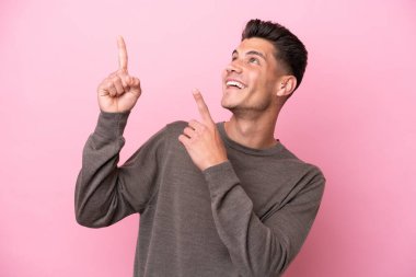 Pembe arka planda izole edilmiş genç beyaz adam işaret parmağıyla işaret etmek harika bir fikir.