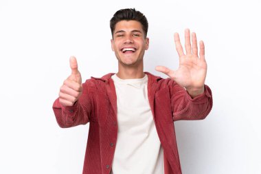 Beyaz arka planda izole edilmiş beyaz tenli genç adam parmakları olan altı kişi sayıyor.