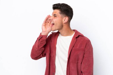 Beyaz arka planda izole edilmiş genç beyaz adam ağzı sonuna kadar açık bağırıyor.